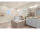 Luxurious bathroom with double vanity and a large soaking tub at 7650 Wandering Way, Orlando, FL 32836