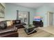 Living room featuring a leather sectional sofa, coffee table and large TV at 4825 Clock Tower Dr, Kissimmee, FL 34746
