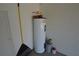 White water heater in a garage corner with various painting supplies at 2221 The Oaks Blvd, Kissimmee, FL 34746