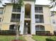Condo building exterior showcasing balconies and landscaping at 8826 Dunes Ct # 207, Kissimmee, FL 34747