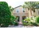Two story townhome with tan siding, double doors, and lush landscaping at 2022 Majorca Dr, Kissimmee, FL 34747