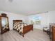 Spacious bedroom with a wooden bed frame, dresser, and a large window at 3241 Wauseon Dr, St Cloud, FL 34772