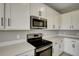 Modern kitchen with white cabinets, quartz countertops, and stainless steel appliances at 155 Bull Frog Ln, Umatilla, FL 32784