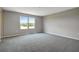 Bright bedroom with gray walls, gray carpet, and two windows at 155 Bull Frog Ln, Umatilla, FL 32784