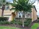 Two-story house with a yellow facade, brick driveway, and lush landscaping at 2131 Tripoli Ct, Kissimmee, FL 34747