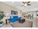 Bright living room with blue sofa, recliner, and view into kitchen at 668 Cordoba Dr, Davenport, FL 33837