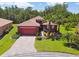 Red two-story house with paved driveway and landscaping at 806 Ebb Tide Ln, Poinciana, FL 34759