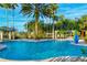 Inviting resort-style pool with palm trees and comfortable seating areas at 806 Ebb Tide Ln, Poinciana, FL 34759