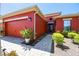 Red house with a two-car garage and a landscaped walkway at 806 Ebb Tide Ln, Poinciana, FL 34759