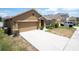 Two-car garage and driveway of a tan one-story house at 1843 Brockridge Rd, Kissimmee, FL 34744