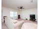 Living room with beige carpet, sofa, ceiling fan, and large window at 1843 Brockridge Rd, Kissimmee, FL 34744