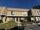 Tan two-story townhouse with a manicured lawn at 6062 N Village Cir # Ge, Orlando, FL 32822