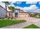 Two-story house with a three-car garage, palm trees, and well-maintained landscaping at 2518 Fontaine Dr, Kissimmee, FL 34741