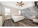 Main bedroom with a tufted bed, accent chairs, and stone feature wall at 2518 Fontaine Dr, Kissimmee, FL 34741