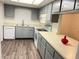 Bright kitchen with gray cabinets, white appliances, and vinyl flooring at 414 Banana Cay Dr # I, South Daytona, FL 32119