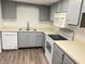 Modern kitchen with gray cabinets and white appliances at 414 Banana Cay Dr # I, South Daytona, FL 32119