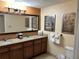 Double vanity bathroom with granite countertops and large mirror at 12539 Floridays Resort Dr # 104 D, Orlando, FL 32821