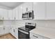 Modern kitchen with white cabinets and stainless steel appliances at 154 Bull Frog Ln, Umatilla, FL 32784