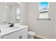 Clean bathroom with white vanity, toilet and a large mirror at 154 Bull Frog Ln, Umatilla, FL 32784