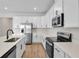 Modern kitchen with white cabinets, stainless steel appliances, and quartz countertops at 154 Bull Frog Ln, Umatilla, FL 32784