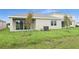 Spacious backyard with grassy area and sliding glass doors at 154 Bull Frog Ln, Umatilla, FL 32784