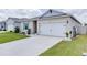 House exterior featuring a two-car garage and well-maintained landscaping at 320 Boardwalk Ave, Haines City, FL 33844