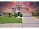 Two story house with attached garage and manicured lawn at 573 Viola Dr, Davenport, FL 33837