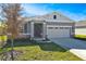 Two-story house with gray siding, stone accents, and a two-car garage at 4248 Sawtooth Ct, Tavares, FL 32778