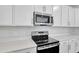 Modern kitchen features stainless steel appliances and white cabinets at 4248 Sawtooth Ct, Tavares, FL 32778