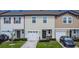 Exterior view of a charming townhome with a two-car garage and well-maintained landscaping at 350 Madison Dr, Davenport, FL 33837