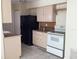 Kitchen with black refrigerator, white stove and beige cabinets at 101 Albert St, Winter Springs, FL 32708