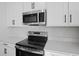 Stainless steel range and microwave in modern kitchen setting at 6333 Clover St, Lake Hamilton, FL 33851