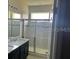 Primary bathroom with dual sinks, a large shower, and granite countertops at 2757 Creekmore Ct, Kissimmee, FL 34746