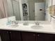 Double vanity bathroom with dark brown cabinets and white countertops at 793 Benoi Dr, Davenport, FL 33896