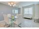 Modern dining room with glass table, white chairs, and a stylish chandelier at 3121 Paradox Circle 207 # 207, Kissimmee, FL 34746