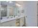 Double vanity bathroom with modern white cabinets and a large mirror at 3121 Paradox Circle 207 # 207, Kissimmee, FL 34746