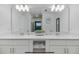 Double vanity bathroom with modern lighting and white cabinets at 3191 Paradox Cir # 205, Kissimmee, FL 34746