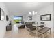 Open concept dining area with glass table, gray chairs, and living room view at 3191 Paradox Cir # 205, Kissimmee, FL 34746