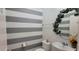 Stylish half bathroom with gray and white striped wall at 2391 Beacon Park Landing Cir, Orlando, FL 32824