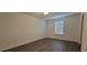 Simple bedroom with wood-look floors and a window with blinds at 2391 Beacon Park Landing Cir, Orlando, FL 32824