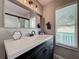 Clean bathroom with dark vanity, white subway tile, and a large mirror at 831 Scenic View Cir, Minneola, FL 34715