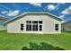 Rear view of a light-colored house with a large window and a grassy yard at 114 Ridge View Dr, Davenport, FL 33837