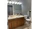 Double vanity bathroom with light wood cabinets and updated fixtures at 7132 Five Oaks Dr, Saint Cloud, FL 34773