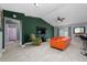Open living room with orange couch, green accent wall, and view of bathroom at 340 Elderberry Ct, Kissimmee, FL 34759