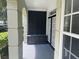 Private condo patio with black storage bench and access to double doors at 239 Longview Ave # 107, Celebration, FL 34747