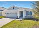 One-story home with gray siding, stone accents, and a two-car garage at 4043 Bannock Ave, Tavares, FL 32778