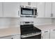 Stainless steel appliances and white cabinets in a modern kitchen at 4043 Bannock Ave, Tavares, FL 32778