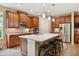Modern kitchen with wood cabinets, granite island, and stainless steel appliances at 694 Irvine Ranch Rd, Kissimmee, FL 34759