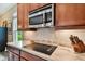 Modern kitchen features a cooktop, microwave, and stylish backsplash at 694 Irvine Ranch Rd, Kissimmee, FL 34759