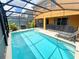 Relaxing screened pool area with lounge chairs and patio furniture at 2955 Beach Palm Ave, Kissimmee, FL 34747